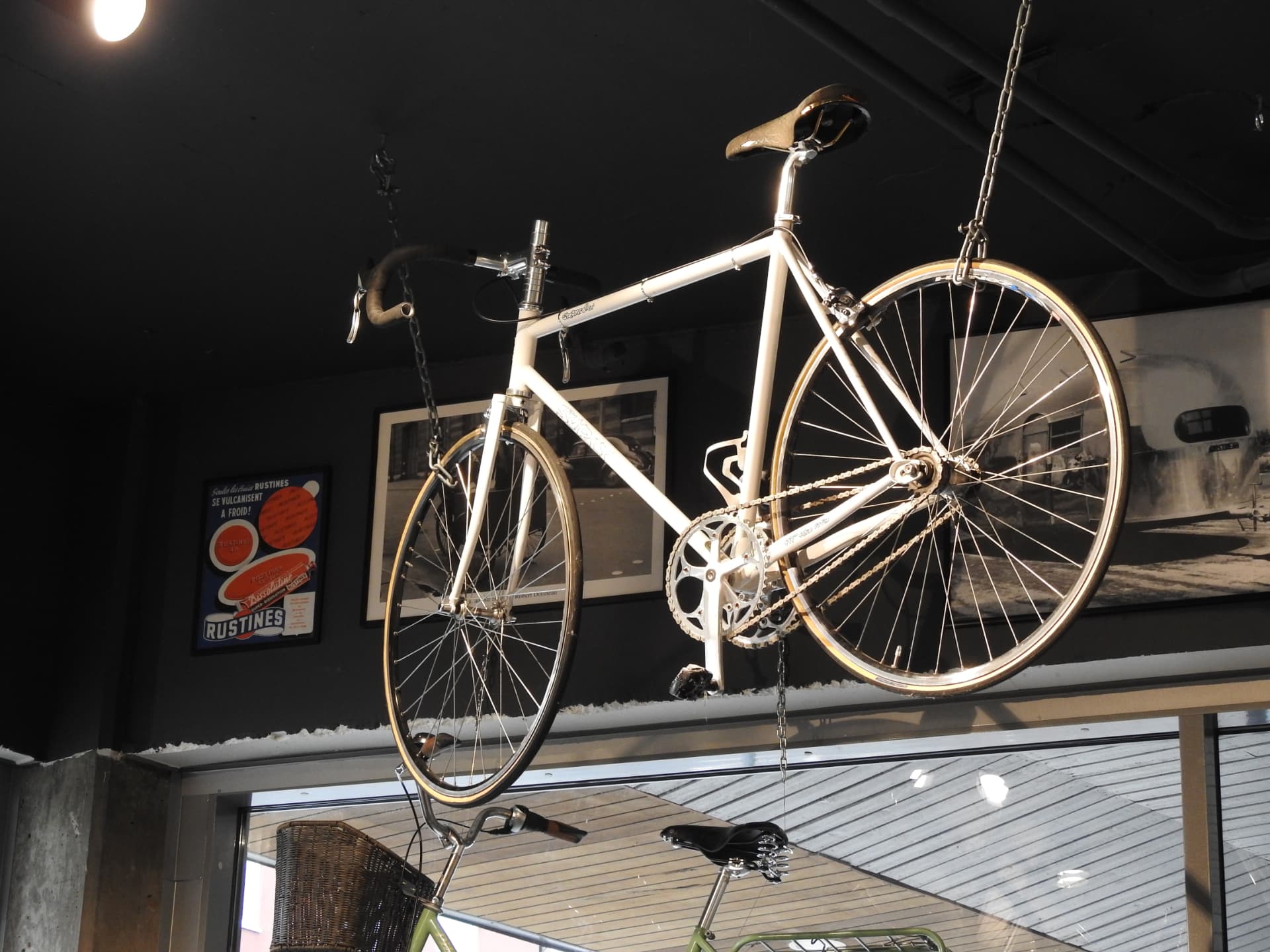 Vit klassisk racercykel som hänger i taket i butiken